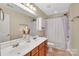 Bathroom featuring double sinks with stained wood cabinets and a shower/tub combo at 7362 Waterwheel Sw St # 280, Concord, NC 28025
