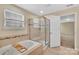 Bright bathroom featuring a large bathtub and separate glass door shower at 7362 Waterwheel Sw St # 280, Concord, NC 28025