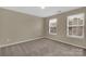 Neutral carpeted bedroom with natural light from two windows and fresh paint at 7362 Waterwheel Sw St # 280, Concord, NC 28025
