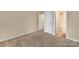 Neutral bedroom with plush carpeting and doors to the bathroom and hallway at 7362 Waterwheel Sw St # 280, Concord, NC 28025