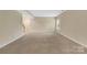 Spacious carpeted living room with staircase and natural light from a window at 7362 Waterwheel Sw St # 280, Concord, NC 28025