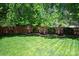 Green backyard with mature trees, shrubs, a wooden privacy fence and well-maintained lawn at 739 Ivy Trail Way, Fort Mill, SC 29715