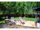Relaxing backyard patio with stone base, featuring modern lounge chairs, table, and landscaped surroundings at 739 Ivy Trail Way, Fort Mill, SC 29715