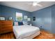 Comfortable bedroom featuring blue wood paneling, hardwood floors, and a cozy bed at 821 Mark St, Belmont, NC 28012