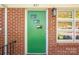 A close-up of a vibrant green front door and brick exterior, showcasing the entrance at 821 Mark St, Belmont, NC 28012