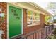 Inviting front door with brick exterior, bright green door and decorative windows at 821 Mark St, Belmont, NC 28012