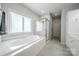 Elegant bathroom featuring a soaking tub, glass shower, and pristine white cabinets at 8271 Camelia Ln, Denver, NC 28037
