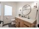 Charming bathroom featuring shiplap wall detail, circular mirror, and a single sink vanity at 8271 Camelia Ln, Denver, NC 28037