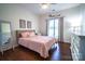 Cozy bedroom featuring a pink bed, hardwood floors, a window, and decorative wall art at 8271 Camelia Ln, Denver, NC 28037