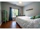 Neutrally decorated bedroom features hardwood floors, blue curtains and a bed with blue and gold pillows at 8271 Camelia Ln, Denver, NC 28037