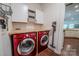 Well-equipped laundry room featuring red washer/dryer set, storage cabinets, and butcher block countertop at 8271 Camelia Ln, Denver, NC 28037