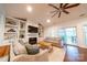 Inviting living room with built-in shelving, a fireplace, ceiling fan, and sliding glass doors at 8271 Camelia Ln, Denver, NC 28037
