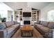 Inviting living room features a cozy fireplace, custom built-ins, and neutral-toned sofas at 8271 Camelia Ln, Denver, NC 28037