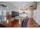 Open office space with wood floors, kitchen in background, dining table and neutral colored furniture at 8271 Camelia Ln, Denver, NC 28037