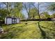 Large backyard featuring a storage shed, fire pit, and ample space for outdoor activities at 833 Old Charlotte Sw Rd, Concord, NC 28027