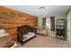 Green bedroom features wood wall, window with curtains, and a bed at 833 Old Charlotte Sw Rd, Concord, NC 28027