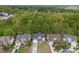 A high angle view of the house and neighborhood, highlighting the lawn and surrounding trees at 8453 Mossy Cup Trl, Harrisburg, NC 28075