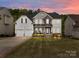 Beautiful two-story home featuring a manicured lawn, stone accents, and a two-car garage at 8453 Mossy Cup Trl, Harrisburg, NC 28075