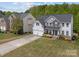 Aerial view of a well-maintained home with a lush green lawn and a long driveway at 8453 Mossy Cup Trl, Harrisburg, NC 28075