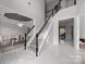 Elegant foyer with a staircase and views into dining and living areas at 8453 Mossy Cup Trl, Harrisburg, NC 28075