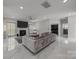 Bright living room features a fireplace, a modern ceiling fan, and marble floors at 8453 Mossy Cup Trl, Harrisburg, NC 28075