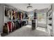 Spacious walk-in closet features custom shelving, storage, a window seat, and a stylish chandelier for ample storage at 8453 Mossy Cup Trl, Harrisburg, NC 28075