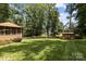 Large, grassy backyard featuring a screened-in porch, picket fence, and storage shed at 8835 Glencroft Rd, Mint Hill, NC 28227