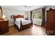 Bedroom with hardwood floors, a four-poster bed, and natural light from the window creates a warm and inviting space at 8835 Glencroft Rd, Mint Hill, NC 28227