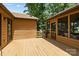 Outdoor wooden deck connecting the main house to a screened-in porch, surrounded by lush greenery at 8835 Glencroft Rd, Mint Hill, NC 28227