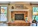 Close-up on a traditional brick fireplace with mantle, flanked by windows for natural light, adding charm to the room at 8835 Glencroft Rd, Mint Hill, NC 28227