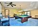 Brightly lit game room with blue carpet, a billiard table, and cozy seating arrangements at 8835 Glencroft Rd, Mint Hill, NC 28227