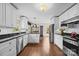 Spacious kitchen featuring white cabinets, stainless steel appliances, and hardwood floors at 8835 Glencroft Rd, Mint Hill, NC 28227