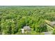 Aerial view showcasing a lush property with mature trees, a stone entrance, and manicured lawns at 914 Elizabeth Ln, Matthews, NC 28105