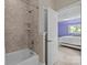 Bathroom with tub shower, tiled surround, and white door at 914 Elizabeth Ln, Matthews, NC 28105