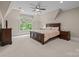 Bedroom showcasing a large window, ceiling fan, and traditional furniture offering style and comfort in a neutral palette at 914 Elizabeth Ln, Matthews, NC 28105