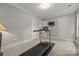 Home exercise room featuring a treadmill, TV, and neutral walls with white trim at 914 Elizabeth Ln, Matthews, NC 28105