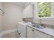 Bright laundry room with modern washer and dryer, granite countertop, and cabinetry at 914 Elizabeth Ln, Matthews, NC 28105
