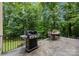 A cozy outdoor dining area features a grill and a table set amongst lush greenery on a spacious patio at 914 Elizabeth Ln, Matthews, NC 28105