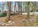 Backyard featuring a fire pit area surrounded by mature trees and landscaping at 10210 Roosevelt Dr, Huntersville, NC 28078