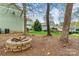 Backyard featuring a fire pit area surrounded by mature trees and landscaping at 10210 Roosevelt Dr, Huntersville, NC 28078