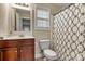 This home features a bathroom with tile flooring, updated vanity, and decorative shower curtain at 10210 Roosevelt Dr, Huntersville, NC 28078