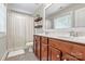 This bathroom features wood cabinets, double sinks, and tiled floors at 10210 Roosevelt Dr, Huntersville, NC 28078