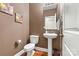 Stylish half bathroom with hardwood floors, pedestal sink, and modern fixtures at 10210 Roosevelt Dr, Huntersville, NC 28078