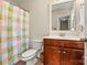 This bathroom features tile floors, a wood vanity, and a floral shower curtain at 10210 Roosevelt Dr, Huntersville, NC 28078