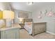 This bedroom features a gray crib, dresser, and neutral walls at 10210 Roosevelt Dr, Huntersville, NC 28078