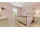 This bedroom features a white crib, neutral walls, and wall decor at 10210 Roosevelt Dr, Huntersville, NC 28078