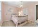 Cozy bedroom with soft pink walls, a charming bed, and decorative floral accents at 10210 Roosevelt Dr, Huntersville, NC 28078