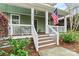 Inviting front porch with rocking chairs and an American flag at 10210 Roosevelt Dr, Huntersville, NC 28078