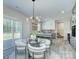 Bright dining area with glass table, modern lighting, and a view into the kitchen at 1033 Harrogate Dr, Bessemer City, NC 28016