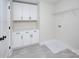 Bright laundry room featuring cabinets, counter space, and modern gray tile flooring at 1033 Harrogate Dr, Bessemer City, NC 28016